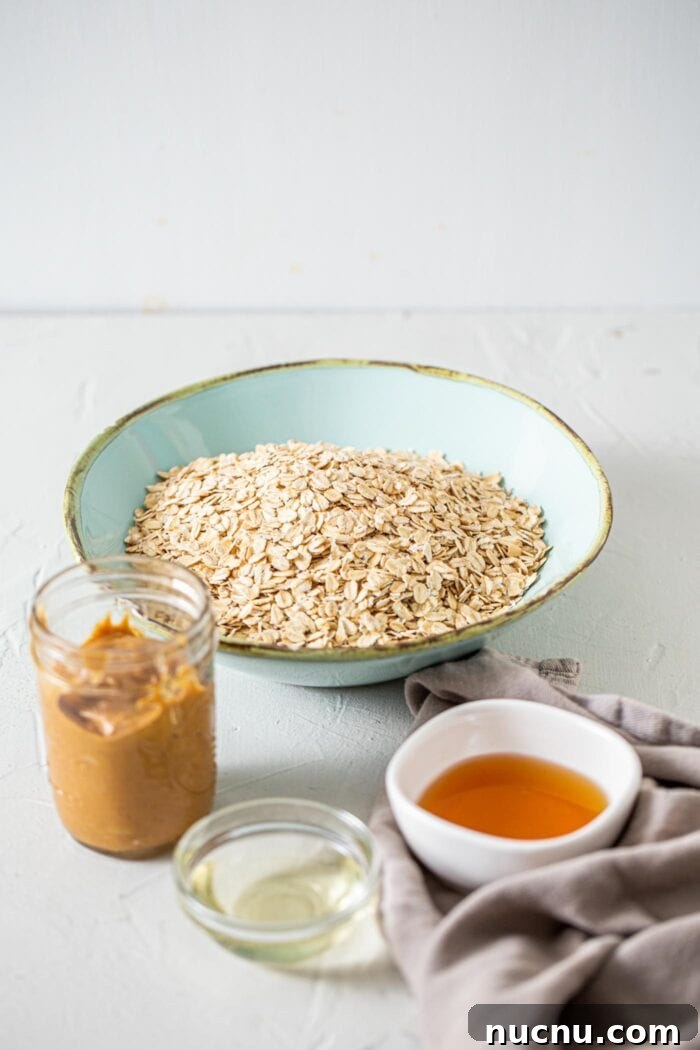 Essential Vegan Pantry Staples for Everyday Cooking 5 Oats, maple syrup, coconut oil and peanut butter in containers on a countertop.