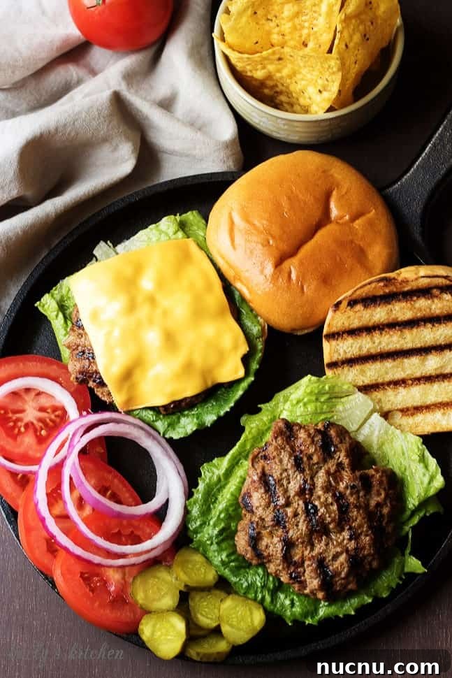 Homemade Juicy Hamburgers Recipe for Classic Flavor 3 Homemade Hamburgers on buns with toppings laid out.