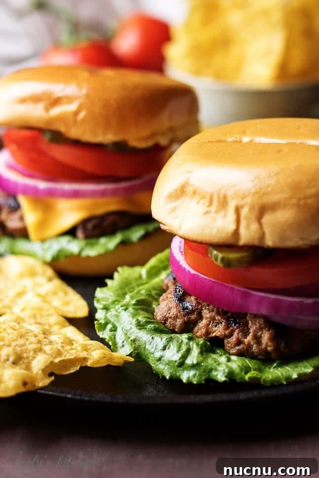 Homemade Juicy Hamburgers Recipe for Classic Flavor 4 Two juicy hamburgers on a skillet with lots of toppings.