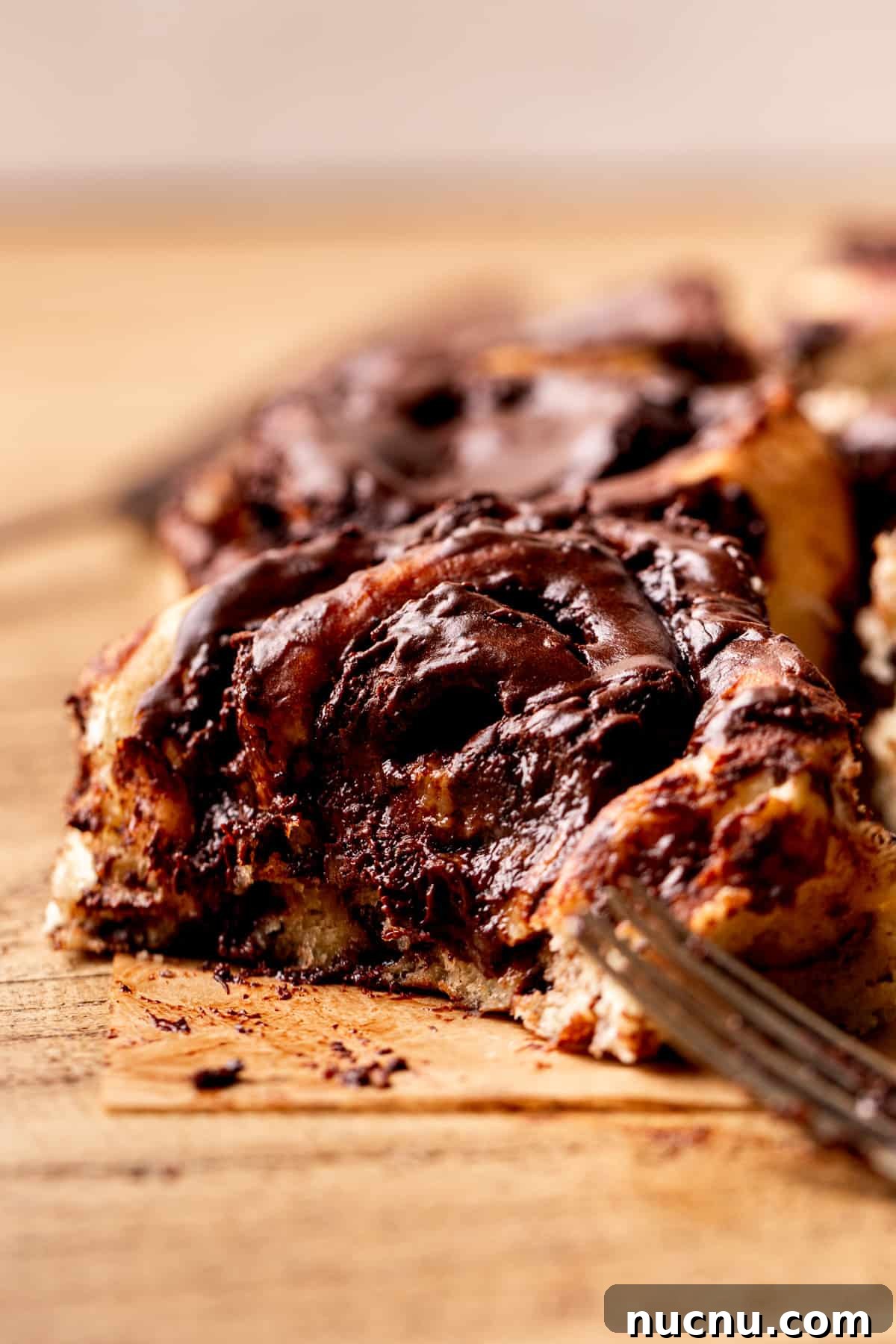 Decadent Chocolate Cinnamon Rolls with Gooey Chocolate Swirl 10 Side view of cinnamon roll with a bite missing.