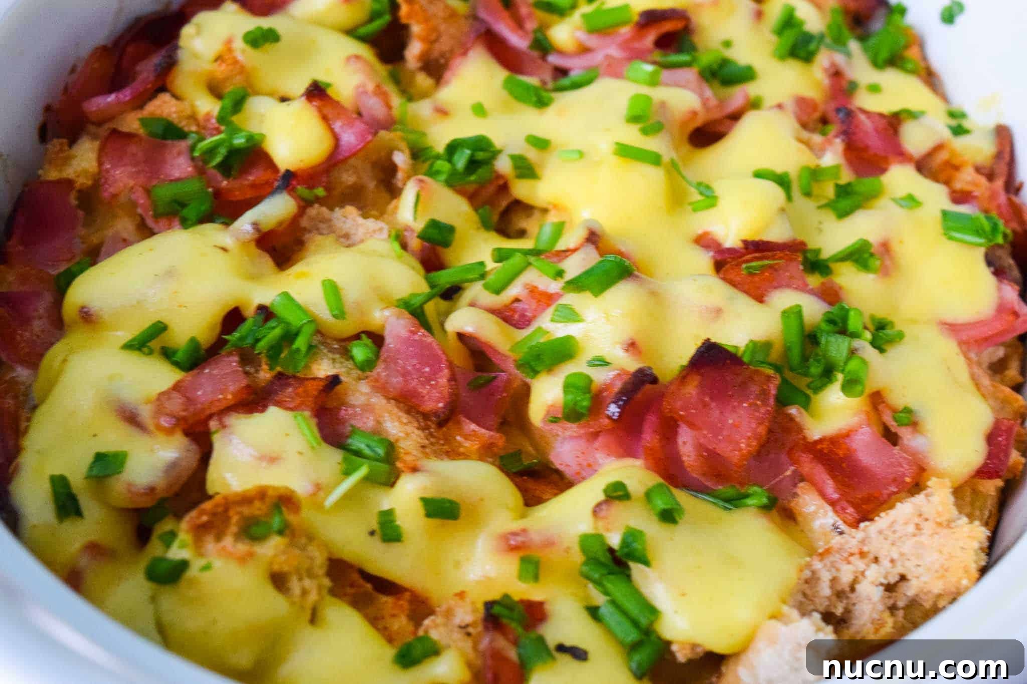Overnight Eggs Benedict Casserole Recipe for Brunch Crowd 5 Overnight Eggs Benedict Casserole topped with chives close up view