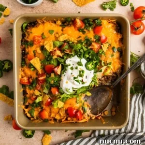 Chicken taco bake in pan with serving spoon scooping in.
