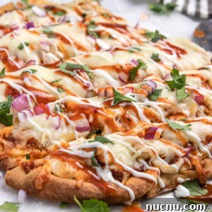 BBQ chicken flatbread with ranch and bbq sauce drizzle and fresh cilantro.
