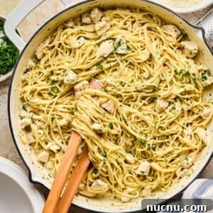 Pot with chicken Alfredo topped with parsley.