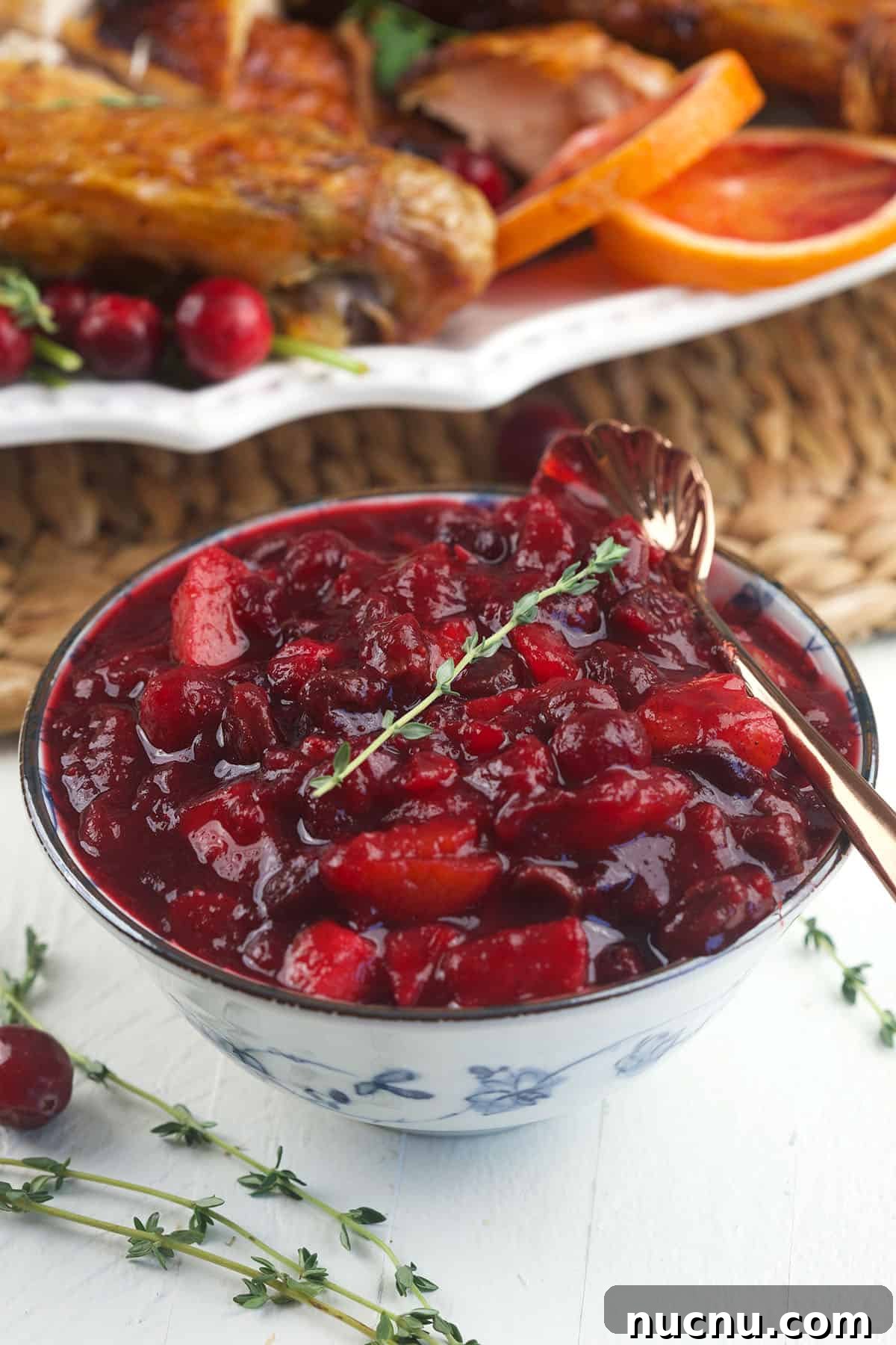 Tangy Cranberry Chutney Recipe for Holiday Roasts and Cheese 2 A bowl of cranberry chutney is placed on a white surface.