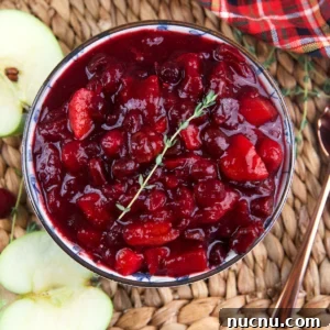 Tangy Cranberry Chutney Recipe for Holiday Roasts and Cheese 6 Halved apples are placed next to a bowl of chutney.