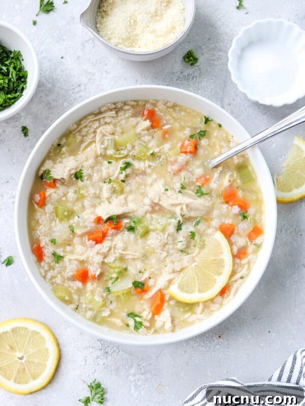 gluten free chicken noodle soup made with pastina in a bowl topped with parsley and parmesan