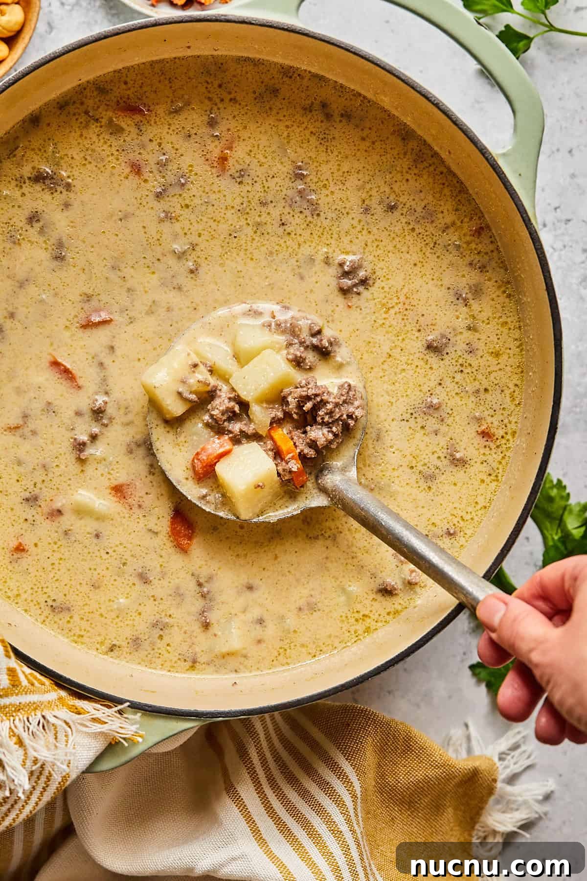 Dairy free cheeseburger soup in a pot with a spoon