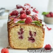 Sliced raspberry loaf cake Ispahan on a white serving board.