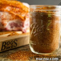 Savory Pork Butt Dry Rub Recipe for Juicy Barbecue 20 jar of pork butt rub with a seasoned pork butt in the background