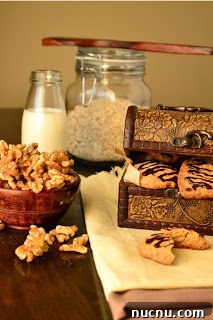 Chewy Oat and Walnut Cookies Recipe 6 oats and walnut cookies with milk and a bowl of walnuts.