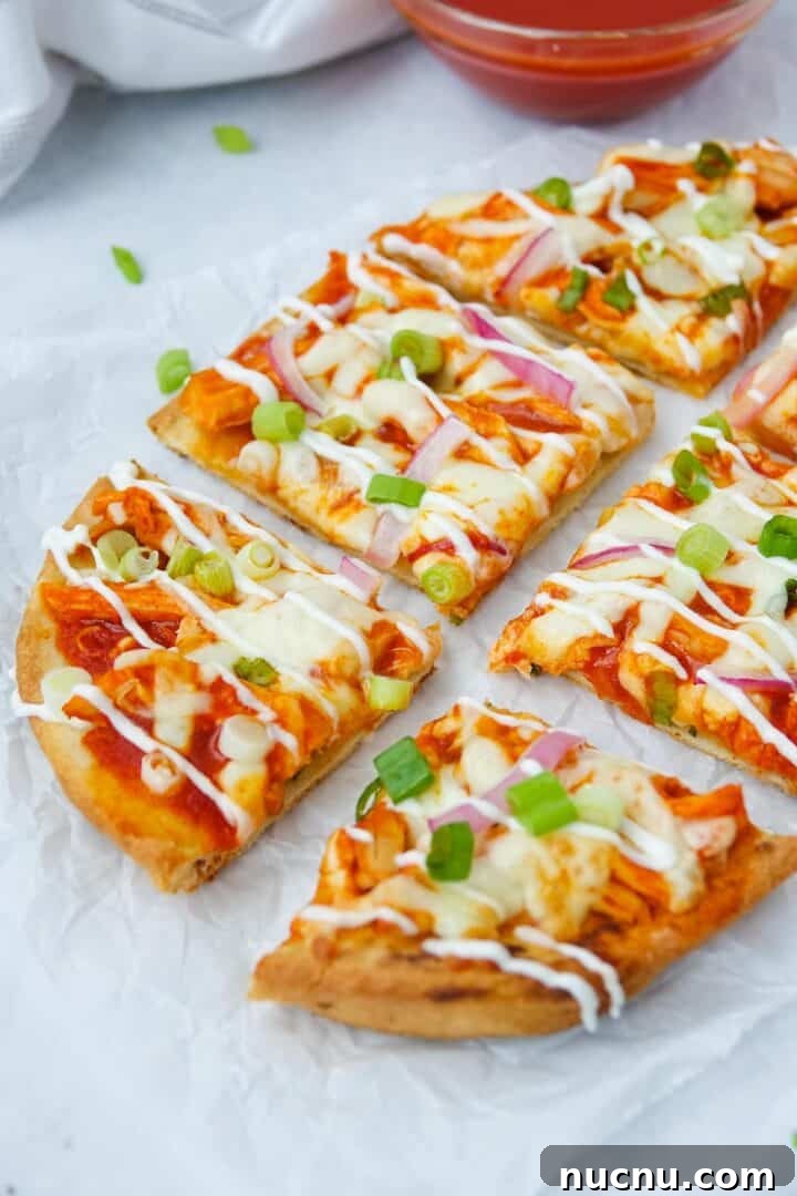 Spicy Buffalo Chicken Flatbread Pizza Recipe for Game Day 4 Close-up photo of buffalo chicken flatbread cut into 6 slices on parchment paper
