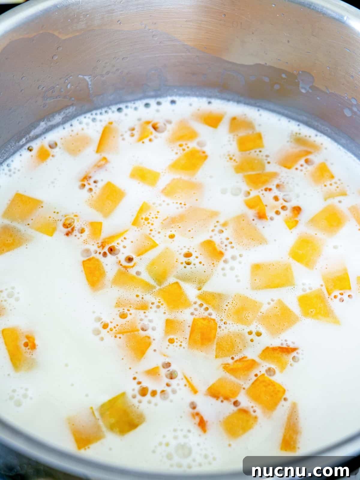 cooking calabasa in sweetened coconut milk in a pot