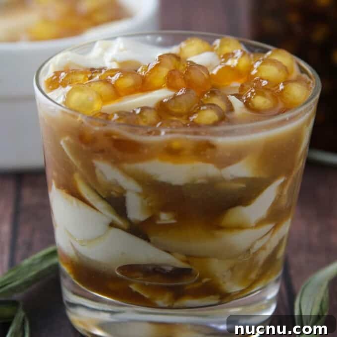 Taho in a clear glass with brown syrup and sago