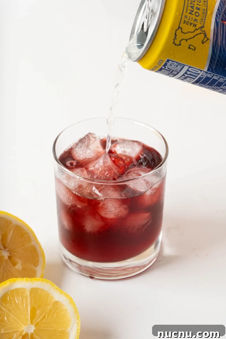 Lemon soda pouring over red wine.