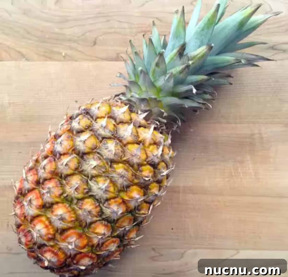 A pineapple was placed on a cutting board. 