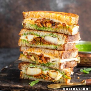 stack of paneer sandwiches cut into half to reveal the inside