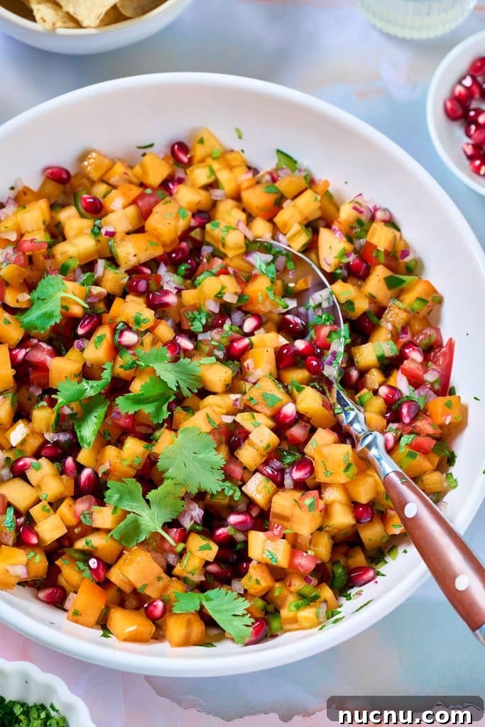 Persimmon Salsa Recipe: Fresh, Tangy Fall Salsa for Chips & Tacos 2 A bowl filled with persimmon salsa fresca garnished with pomegranate arils and fresh cilantro.
