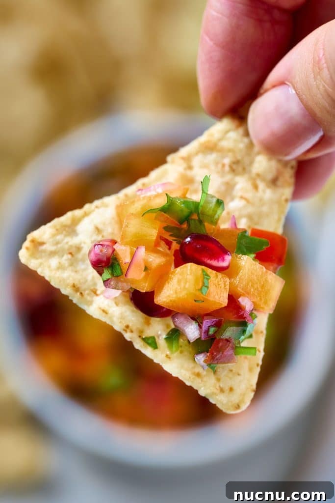 Persimmon Salsa Recipe: Fresh, Tangy Fall Salsa for Chips & Tacos 6 A tortilla chip scooping salsa fresca.