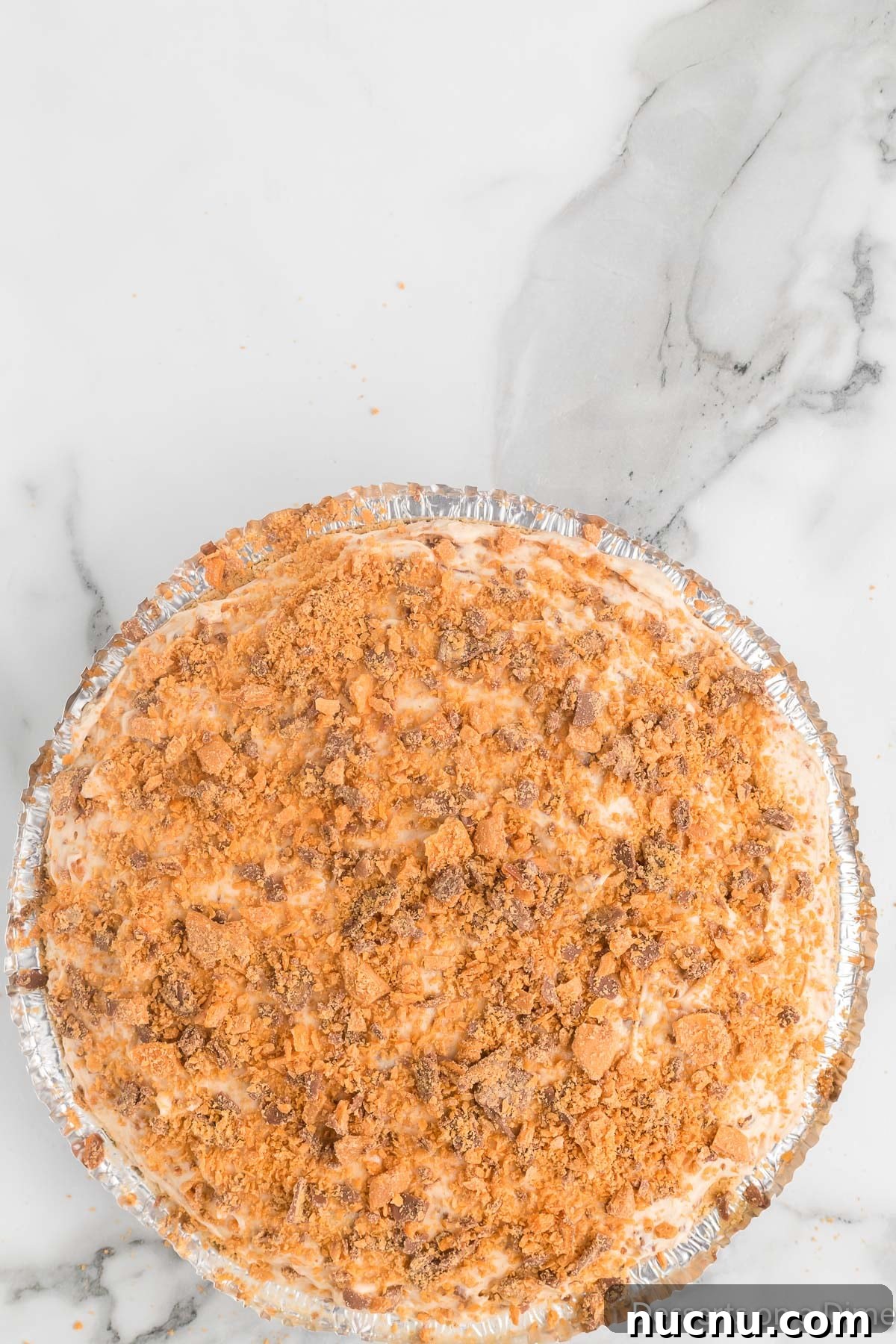 Decadent Butterfinger Pie Recipe — How to Make It at Home 9 Pie topped with candy mixture.