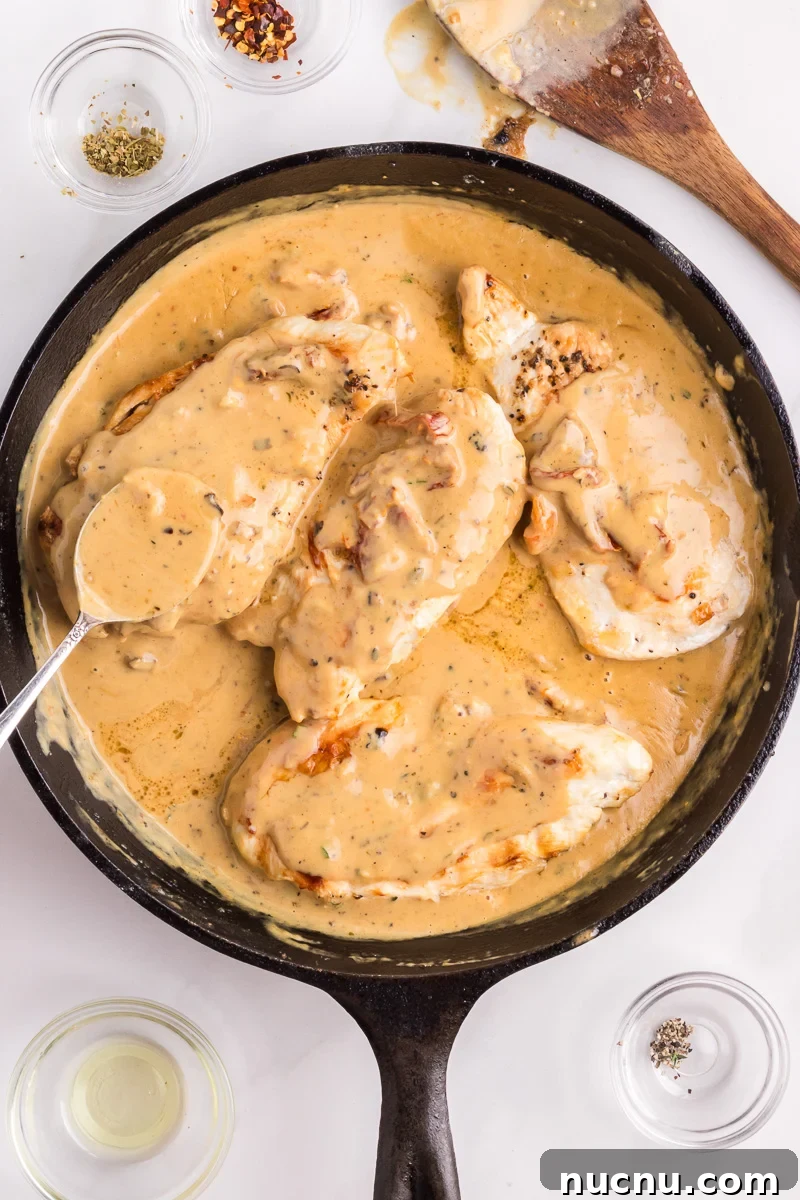 Marry me chicken in the skillet with creamy sauce spooned on it.