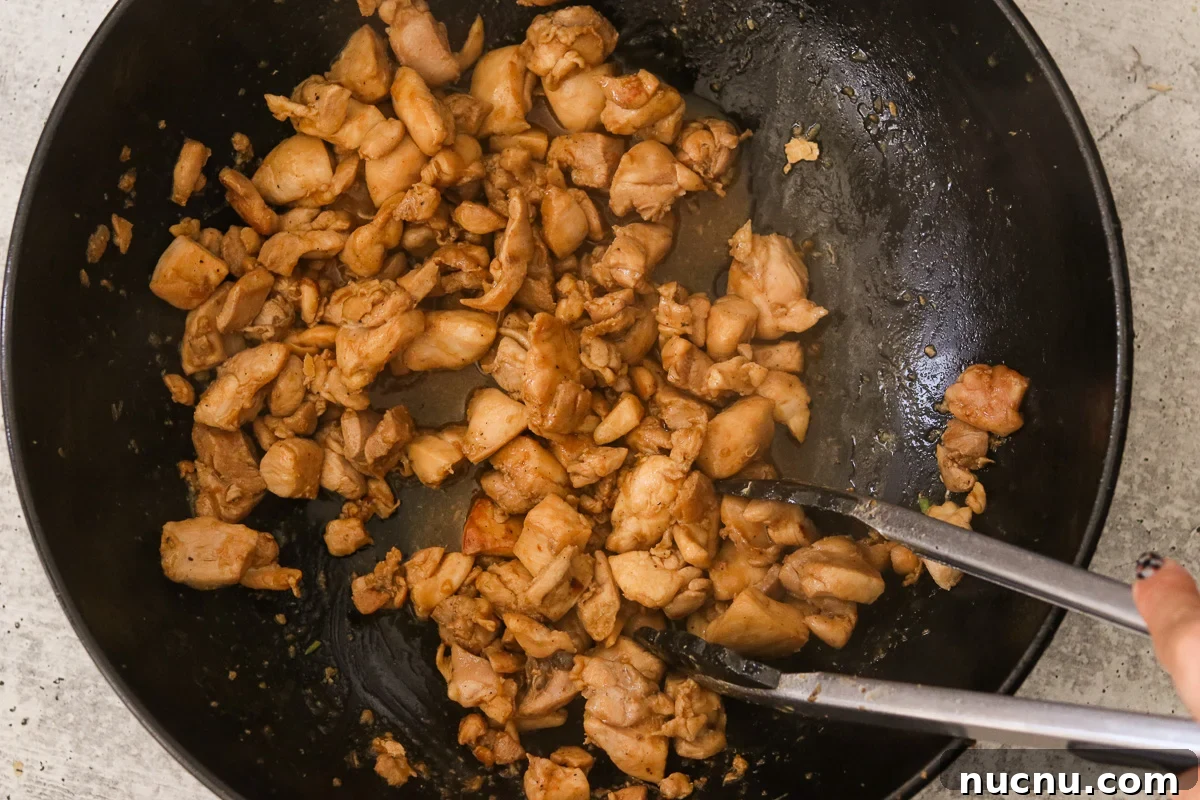 Hibachi Chicken Bowl Recipe — Japanese Steakhouse Copycat 9 Marinated chicken cooking in a skillet.