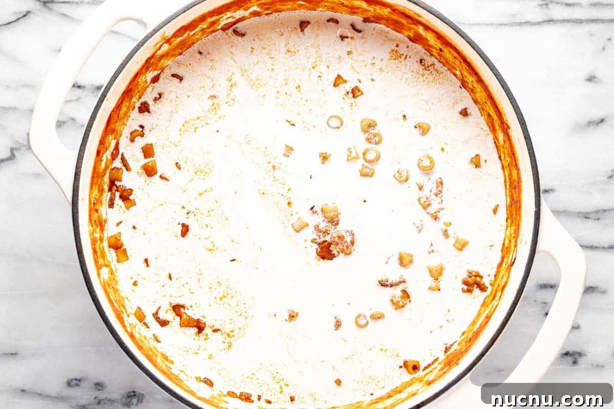 Creamy Beef and Tomato Noodle Soup Recipe 7 Heavy cream added to a large pot of tomato soup with ground beef.