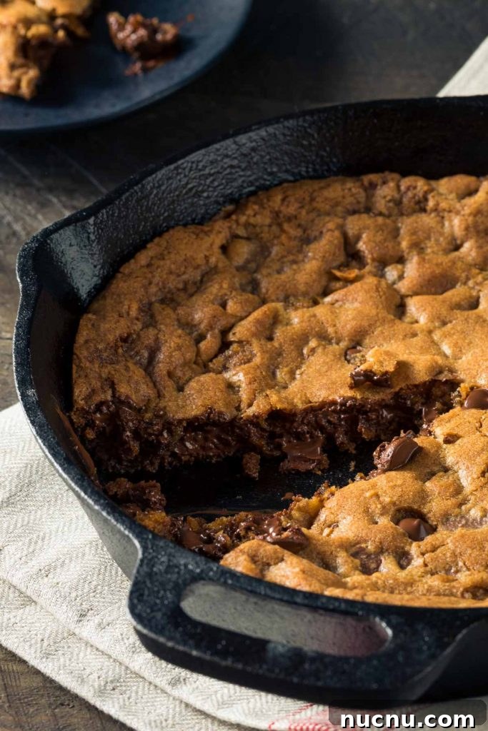 Skillet Chocolate Chip & Toffee Cookie (Pizookie Recipe) 6 a skillet cookie in a cast iron pan just out of the oven with one piece removed