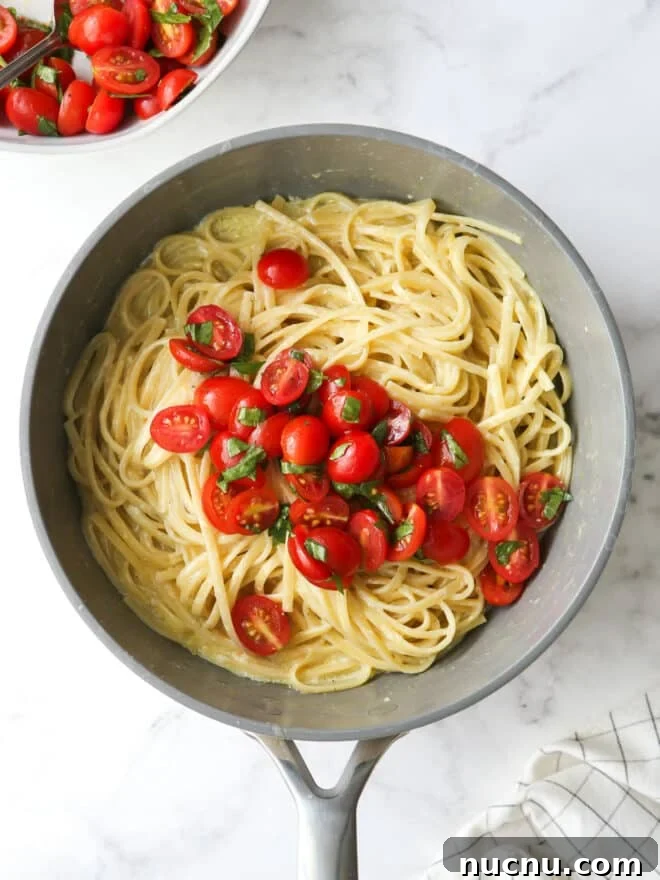 Lemon Pasta with Cherry Tomatoes and Fresh Basil Recipe 7 adding marinated tomatoes to pasta in pot
