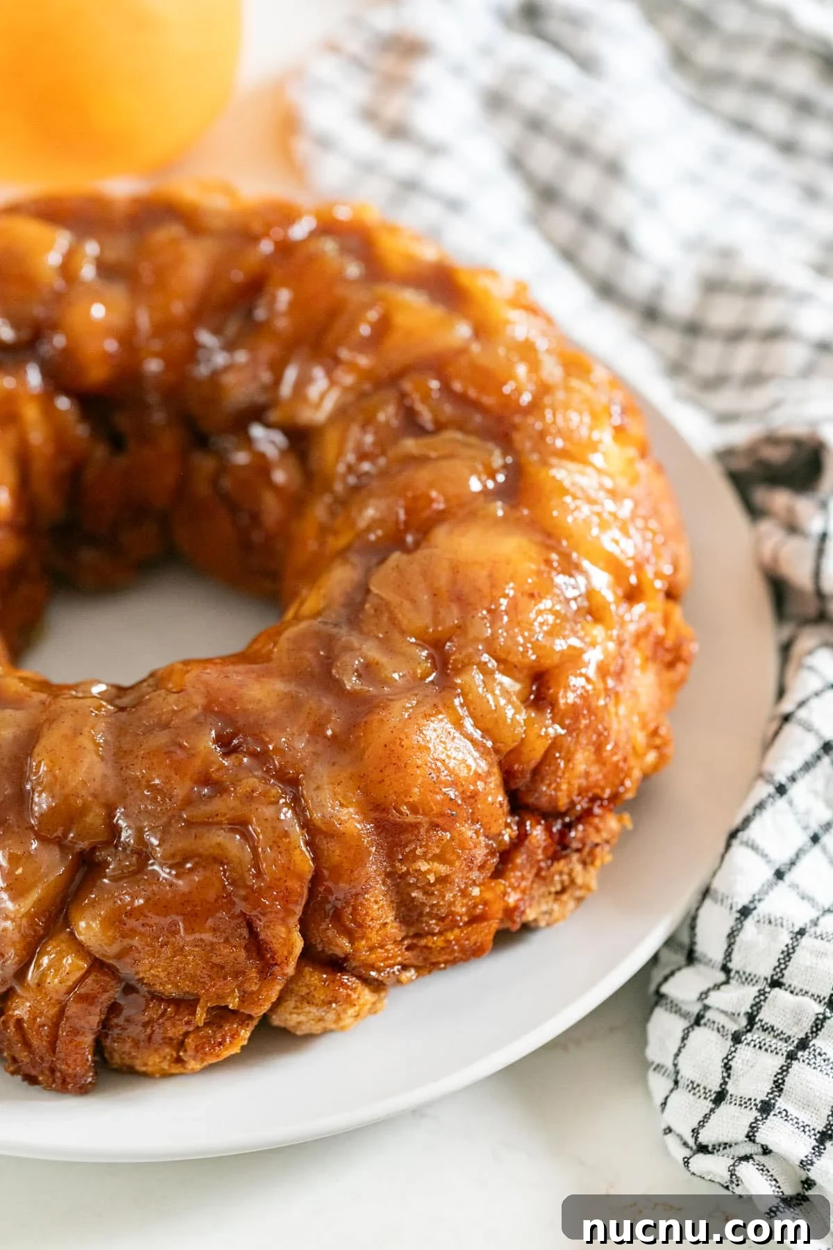 Orange Cinnamon Pull-Apart Loaf: Zesty Sweet Morning Bread 10 A side angle shot of the side half of orange monkey bread with an orange and a checkered napkin in the background.