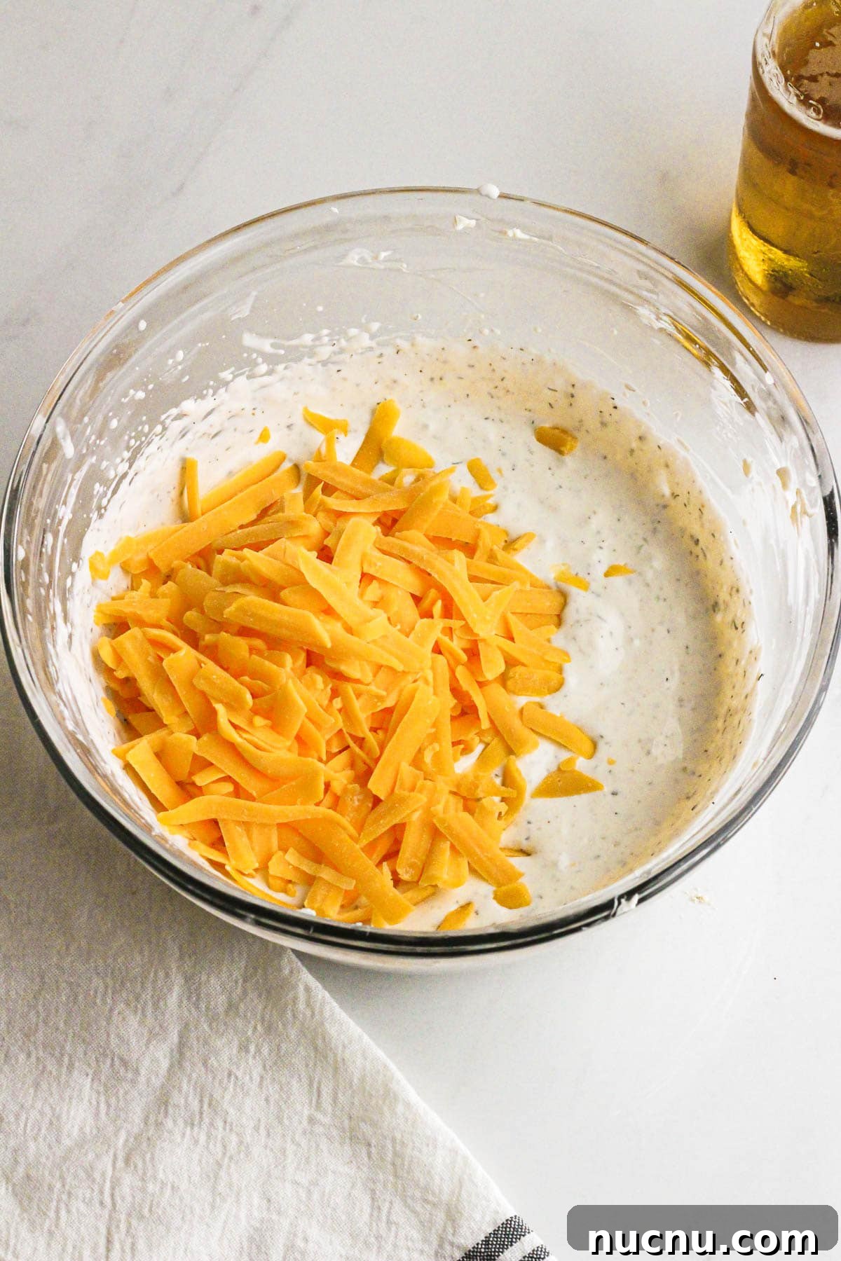 Shredded cheddar being added