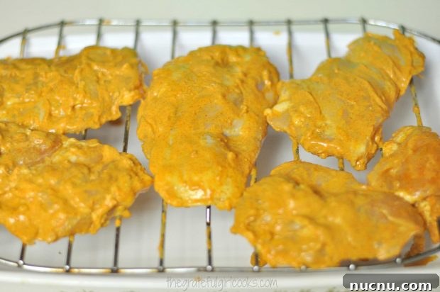 Tandoori Chicken ready for broiling Tandoori chicken pieces on a wire rack ready for the oven.