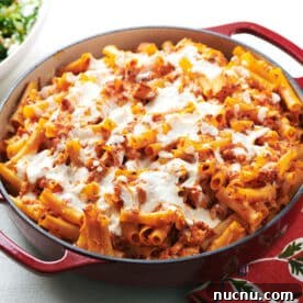 Ultimate Baked Pasta Recipes for Crowd-Pleasing Dinners 13 Chicken Parmesan Baked Ziti in red pan on table.
