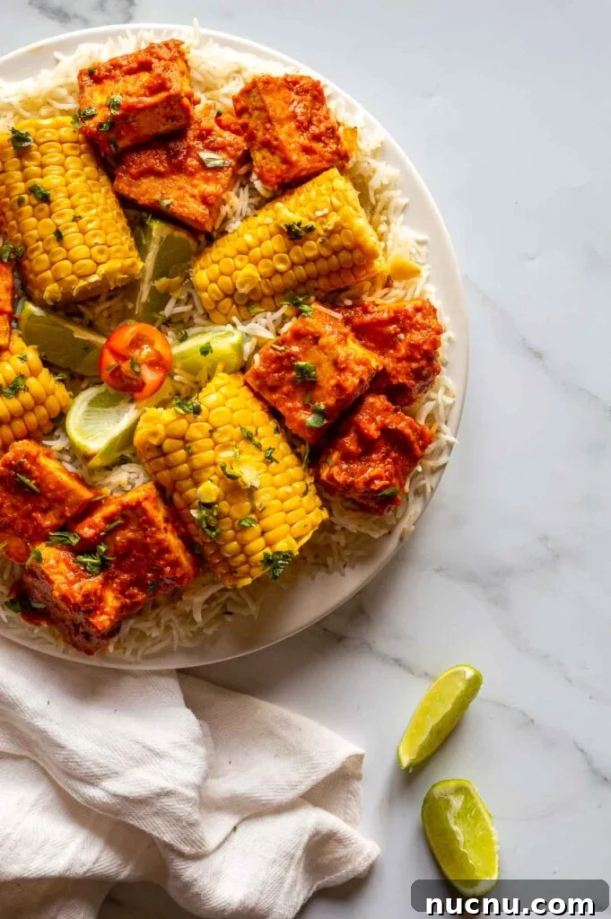 Fiery Peri-Peri Tofu Recipe for Bold, Smoky Flavor 7 top down view of a plate with tofu in red-orange sauce and corn on the cob