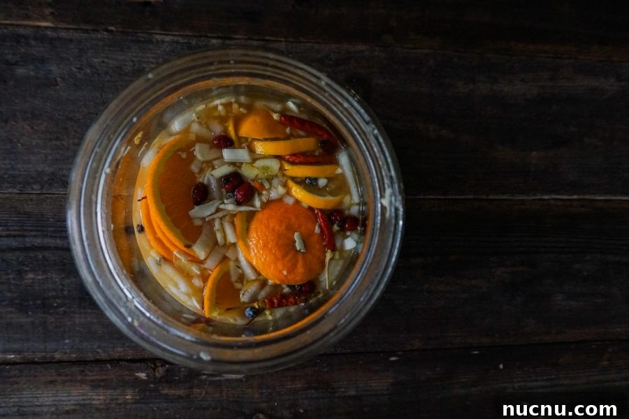 looking into a glass jar filled with fire cider ingredients