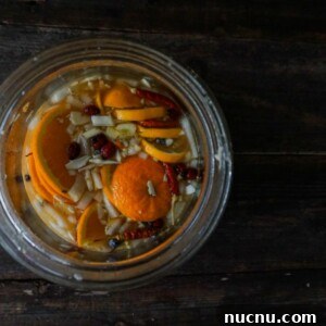 looking into a glass jar filled with fire cider ingredients