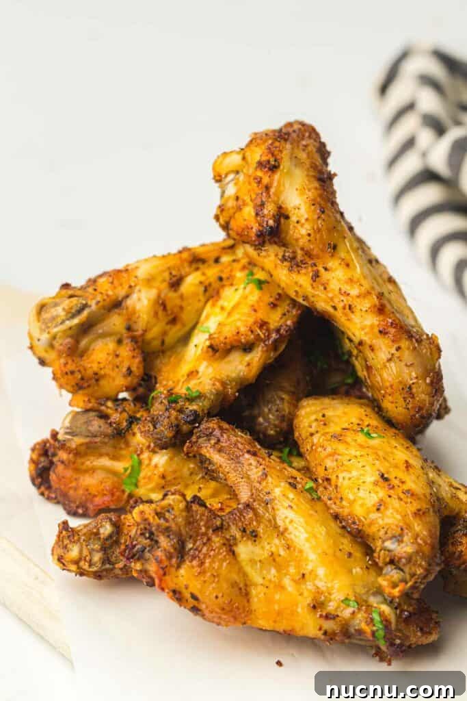 Crispy Air Fryer Chicken Wings — Extra Crunch in 25 Minutes 10 A stack of chicken wings on a cutting board ready for air frying.