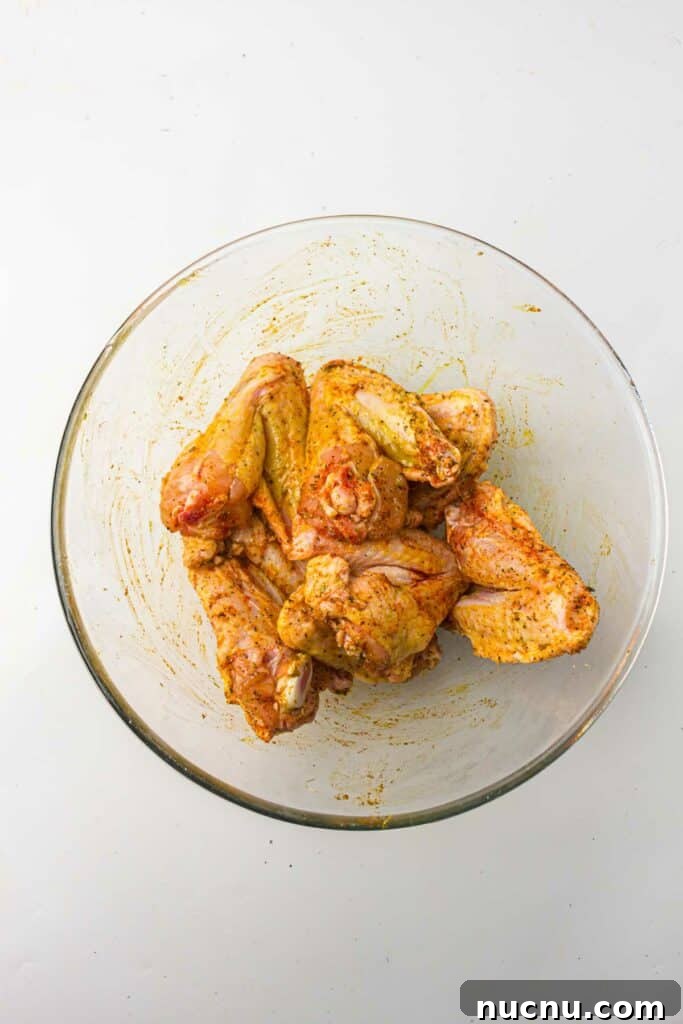 Crispy Air Fryer Chicken Wings — Extra Crunch in 25 Minutes 6 Chicken wings in a bowl with seasonings.
