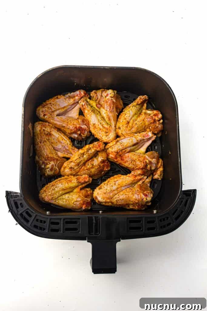 Crispy Air Fryer Chicken Wings — Extra Crunch in 25 Minutes 7 An air fryer pan with chicken wings in it.