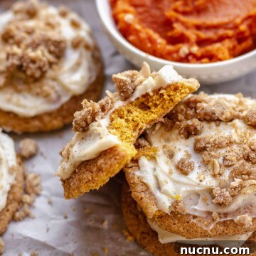 A bite removed from a pumpkin cheesecake cookie resting on another cookie.