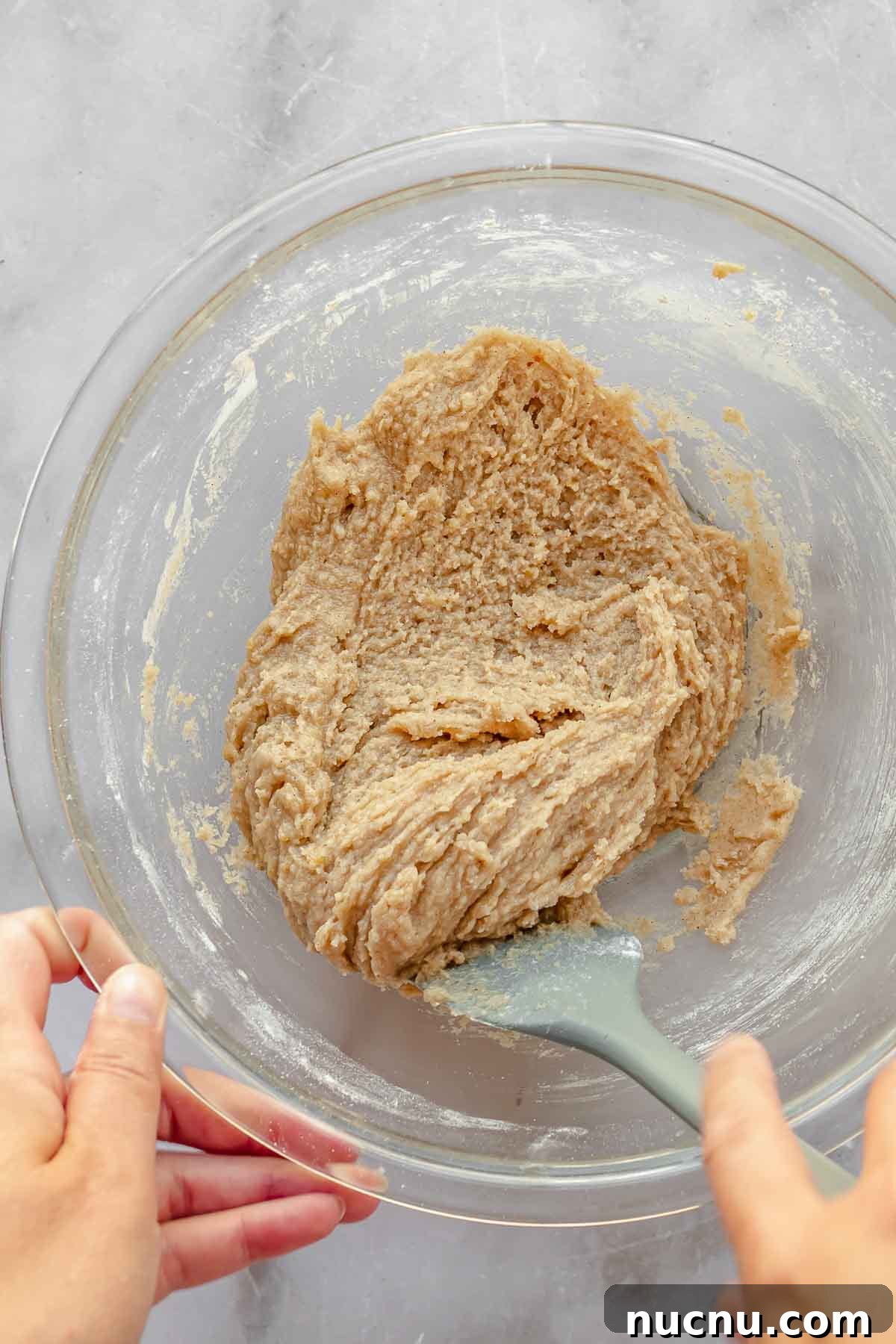 A spatula mixing cake batter in a bowl.