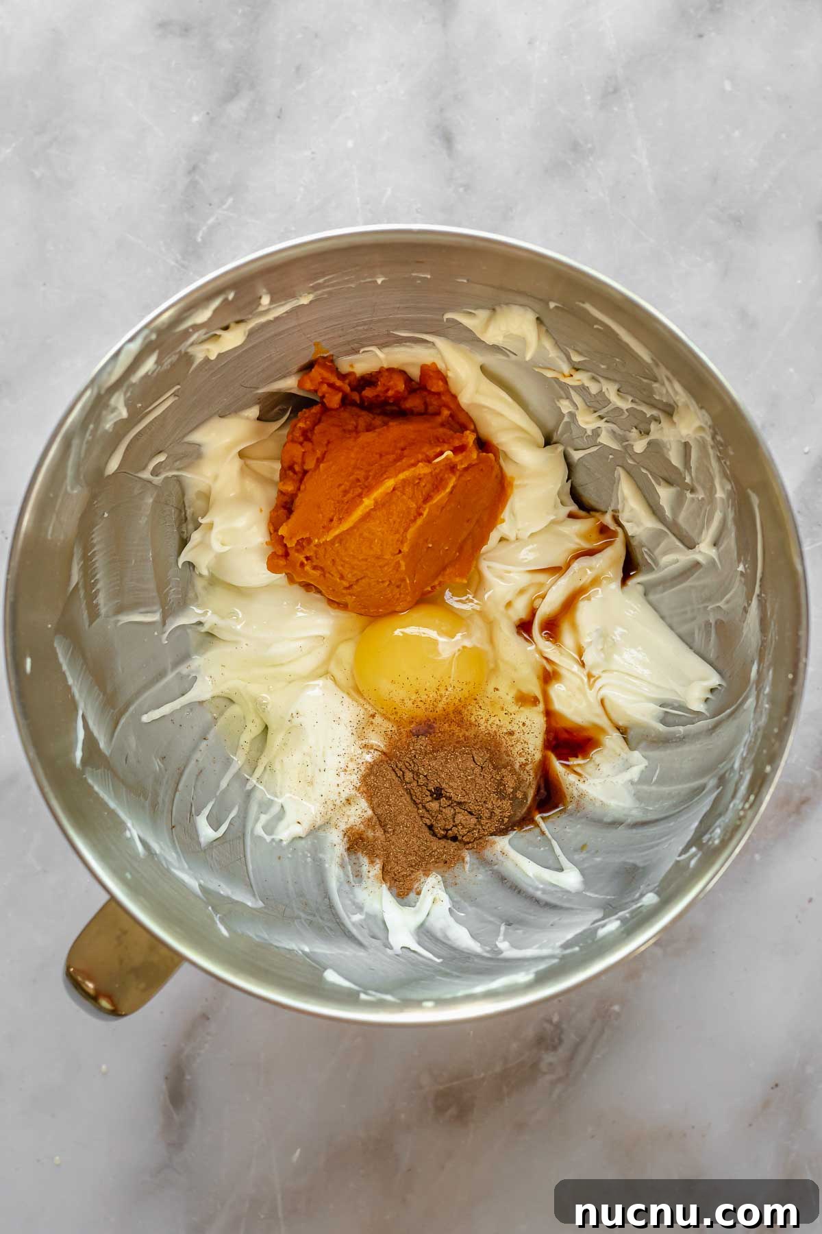 Pumpkin gooey bar filling in a stand mixer bowl.