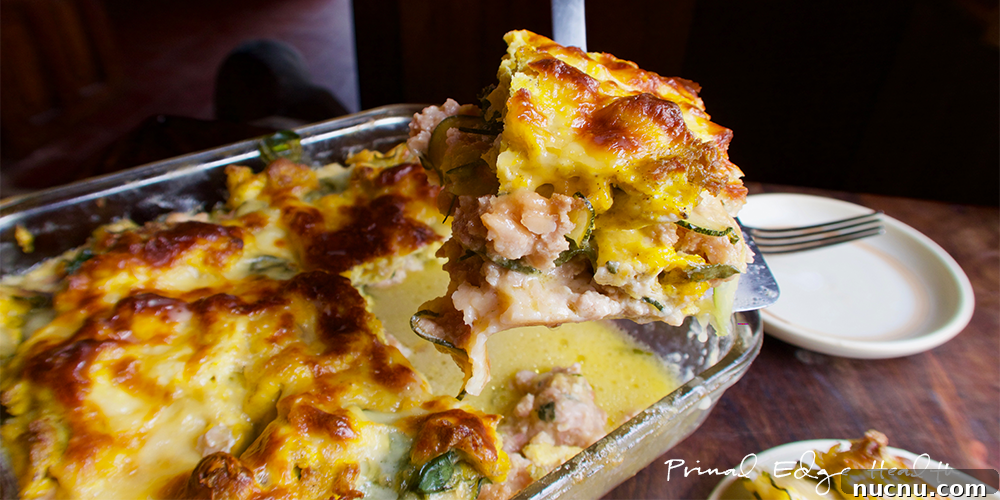Breakfast lasagna being served at table.