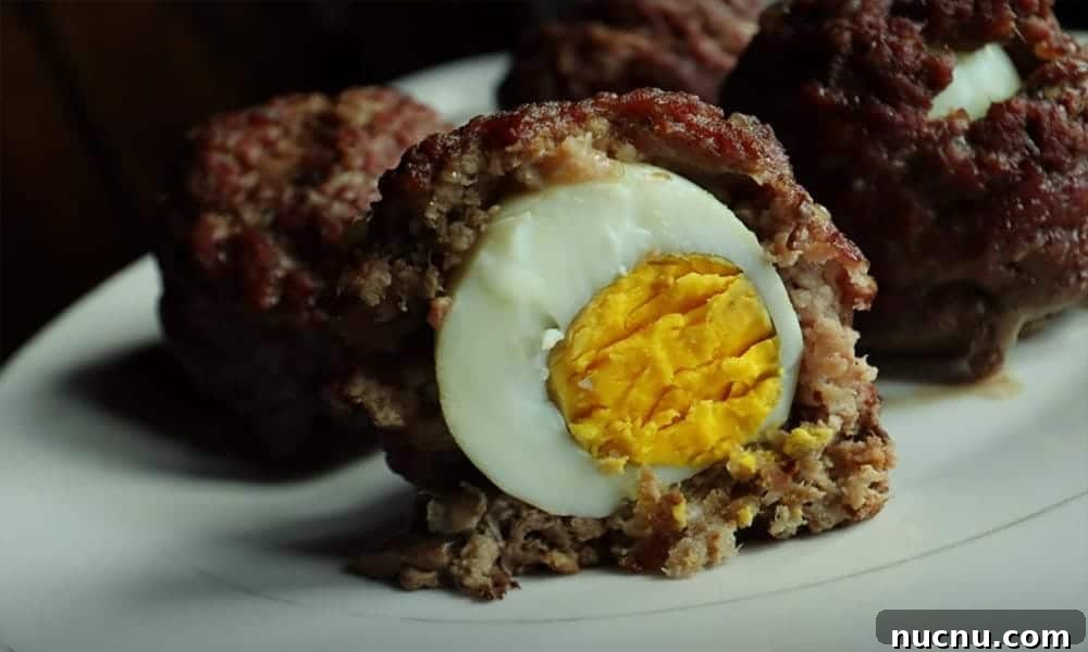Scotch eggs with ground beef one cut in half.