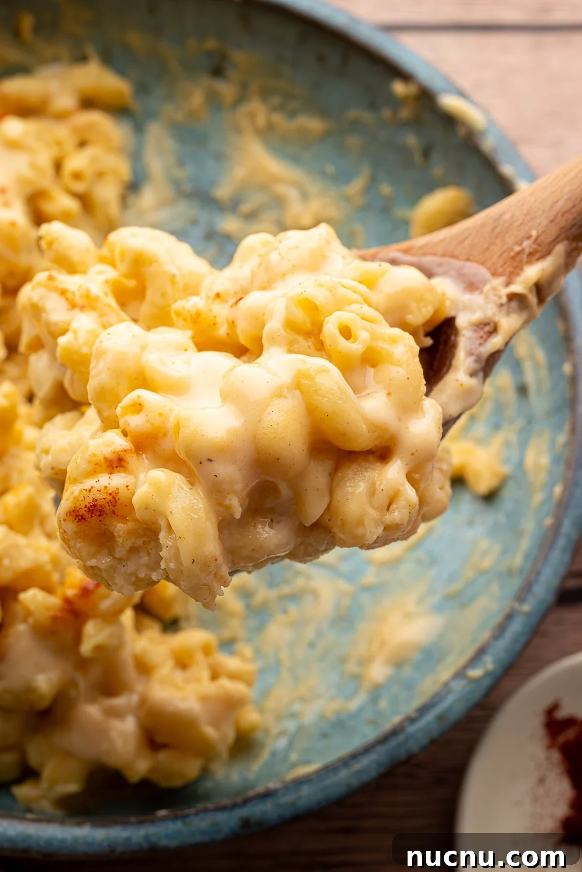 Creamy Stovetop Monterey Jack Mac and Cheese Recipe 9 A wooden spoon with a scoop of the Mac and cheese that is light in color.