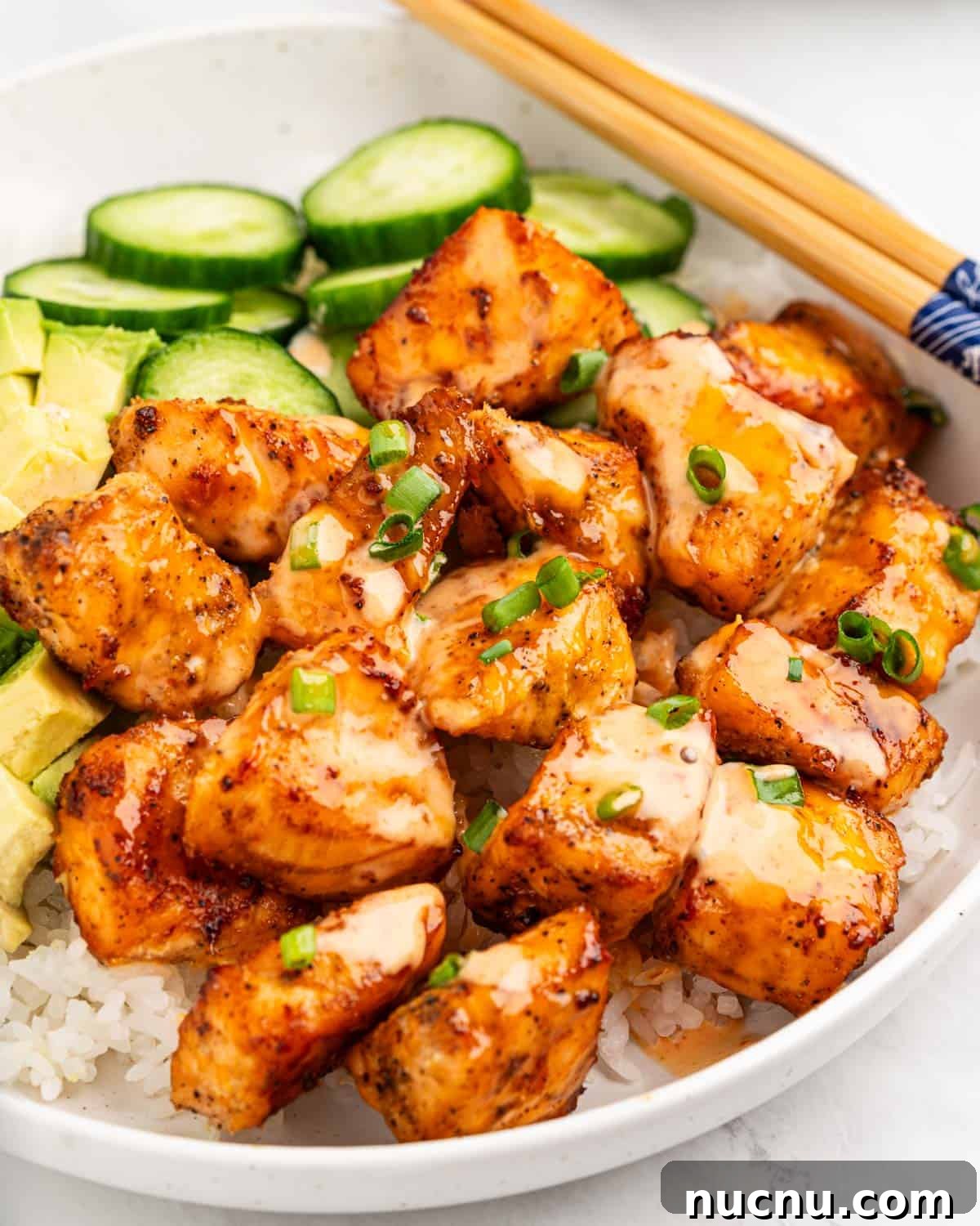 Crispy Air Fryer Salmon Bites with Lemon Garlic Dip 7 Close up of cubes of crispy air fryer salmon drizzled with spicy sauce.