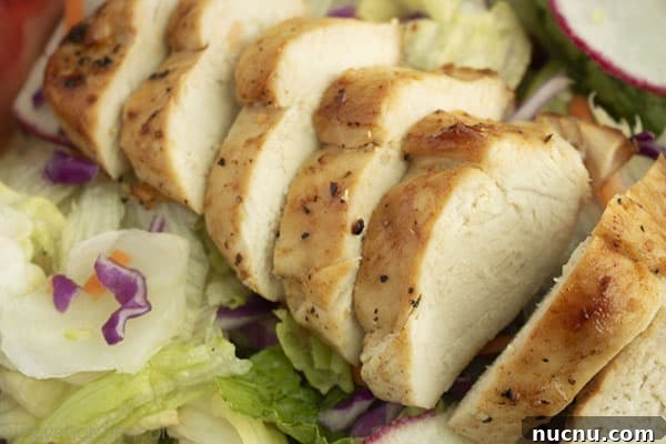 Juicy Air Fryer Chicken Breasts: Quick Crispy Recipe in 20 Minutes 11 Sliced chicken on a salad mixture