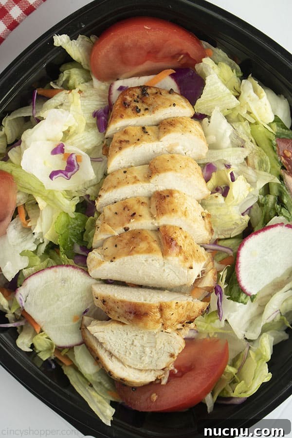 Juicy Air Fryer Chicken Breasts: Quick Crispy Recipe in 20 Minutes 4 Sliced Chicken breasts on a green salad with black dish