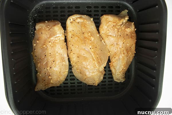 Juicy Air Fryer Chicken Breasts: Quick Crispy Recipe in 20 Minutes 10 Uncooked and seasoned chicken breasts in a air fryer basket