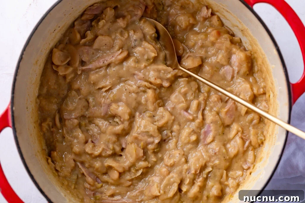 Southern-Style Creamy Butter Beans Recipe: Comforting Soul Food 2 creamy butterbeans in a dutch oven with a gold spoon
